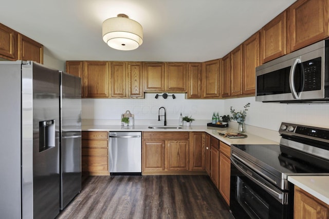 101 Circle Dr, Baltimore, OH 43105 - kitchen with stainless steel appliances, brown cabinetry, light countertops, dark wood finished floors, and decorative backsplash
