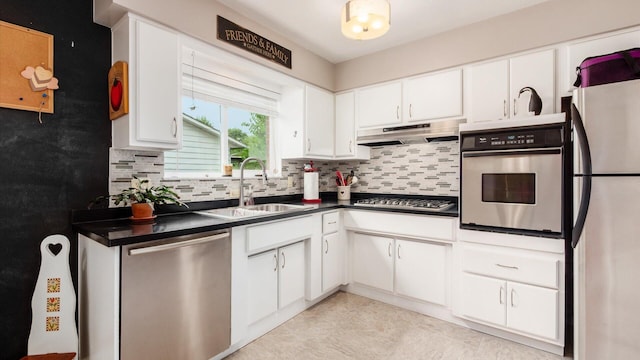 452 Jefferson Rd, Newark, OH 43055 - kitchen with stainless steel appliances, dark countertops, backsplash, white cabinetry, and under cabinet range hood