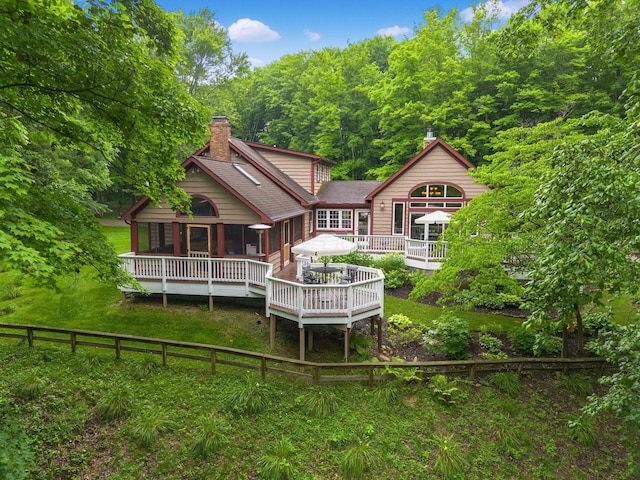 8622 Lott Rd, Marengo, OH 43334 - rear view of property with a chimney, a deck, a wooded view, and a shingled roof