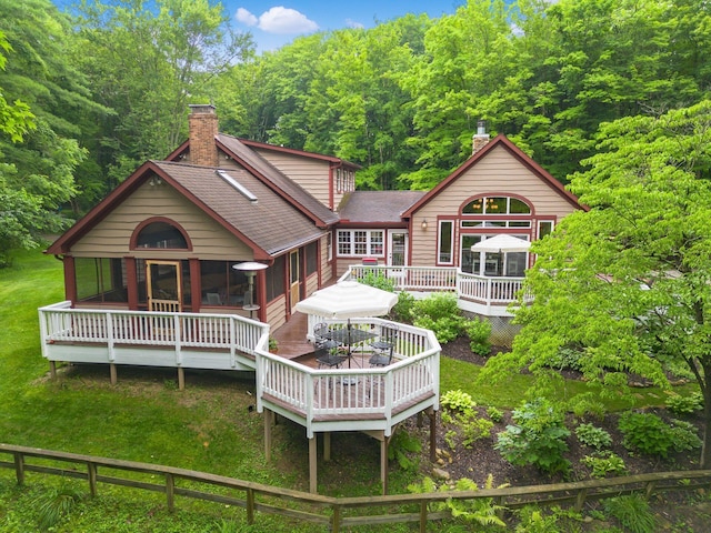 8622 Lott Rd, Marengo, OH 43334 - back of house featuring a chimney, a shingled roof, a wooden deck, a lawn, and outdoor dining space