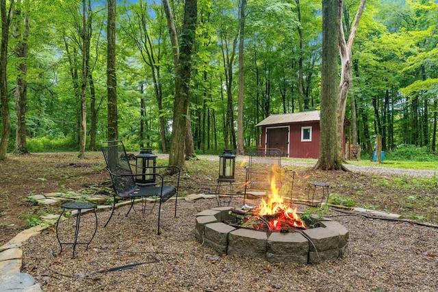8622 Lott Rd, Marengo, OH 43334 - view of yard with a fire pit, an outdoor structure, and a forest view