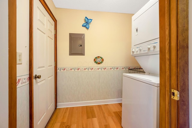 154 Oak Creek Pl, Columbus, OH 43230 - laundry room featuring electric panel, estacked washer and dryer, light wood-style floors, and a wainscoted wall