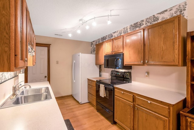 154 Oak Creek Pl, Columbus, OH 43230 - kitchen with black appliances, light countertops, light wood-style floors, and brown cabinets