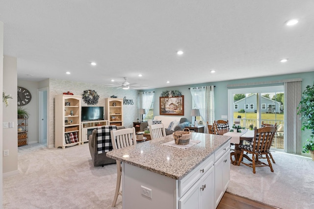 211 Talla Rd S, Delaware, OH 43015 - kitchen with a kitchen island, white cabinets, recessed lighting, light stone counters, and open floor plan