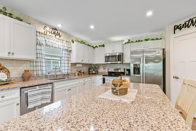 211 Talla Rd S, Delaware, OH 43015 - kitchen with stainless steel appliances, white cabinetry, tasteful backsplash, light stone countertops, and recessed lighting