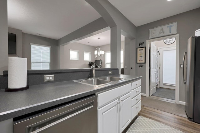 7911 Ashenden Dr, Blacklick, OH 43004 - kitchen with appliances with stainless steel finishes, white cabinetry, light wood-type flooring, a chandelier, and dark countertops