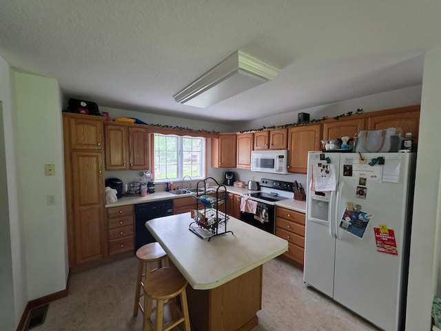 1919 Jared Pl, Lima, OH 45805 - kitchen with white appliances, light countertops, brown cabinetry, a center island, and a kitchen bar