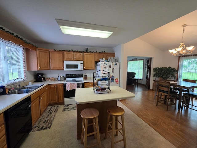 1919 Jared Pl, Lima, OH 45805 - kitchen with white appliances, a chandelier, light countertops, brown cabinetry, and a kitchen island