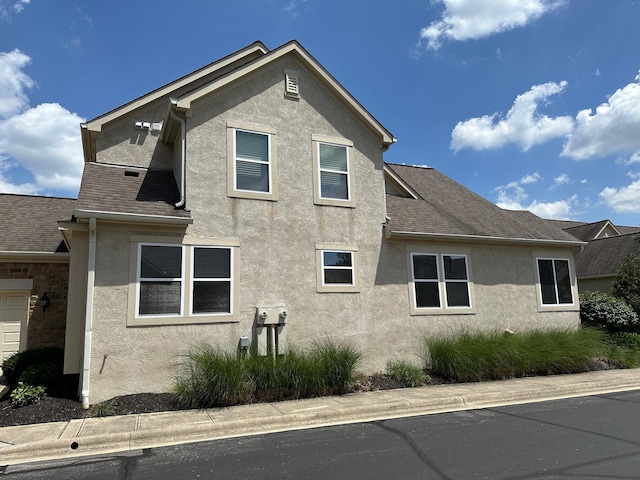 1013 Bluff Crest Dr, Columbus, OH 43235 - view of side of home featuring stucco siding and roof with shingles