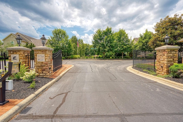 1013 Bluff Crest Dr, Columbus, OH 43235 - view of asphalt road with street lighting, curbs, a gate, and a gated entry