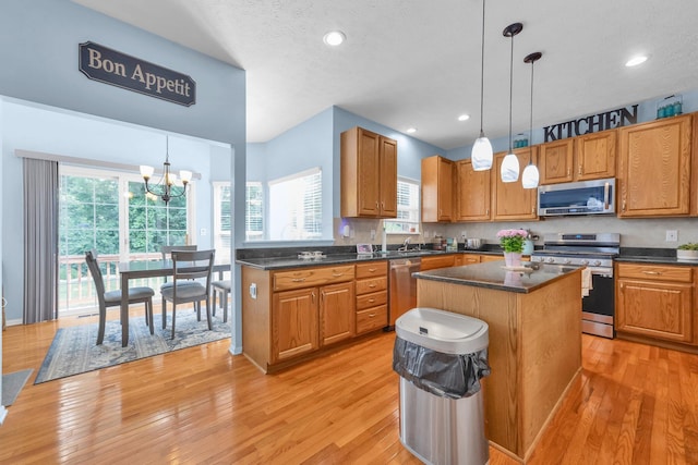 6598 Estate View Dr S, Blacklick, OH 43004 - kitchen featuring stainless steel appliances, dark countertops, light wood-type flooring, a kitchen island, and decorative light fixtures