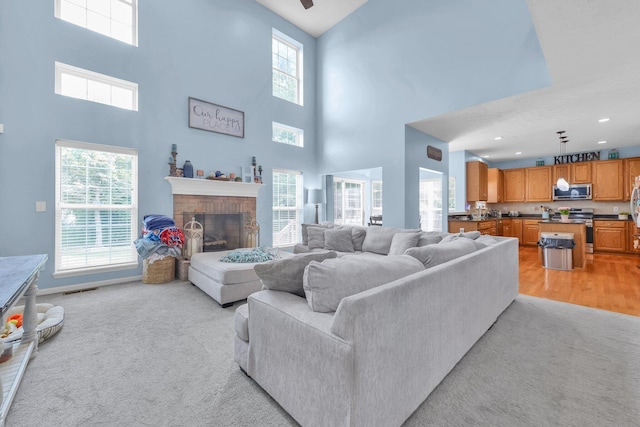 6598 Estate View Dr S, Blacklick, OH 43004 - living room featuring a towering ceiling, a fireplace, ceiling fan, recessed lighting, and light wood finished floors