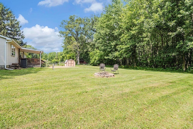 7472 Davis Rd, Hilliard, OH 43026 - view of grassy yard with a shed, a fire pit, and a deck