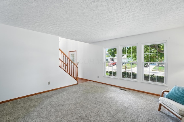 526 Springwood Lake Dr, Columbus, OH 43230 - unfurnished living room with healthy amount of natural light, carpet floors, stairs, and a textured ceiling