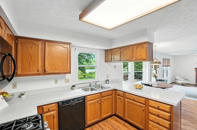 526 Springwood Lake Dr, Columbus, OH 43230 - kitchen featuring black appliances, a peninsula, light countertops, light wood-style flooring, and a textured ceiling