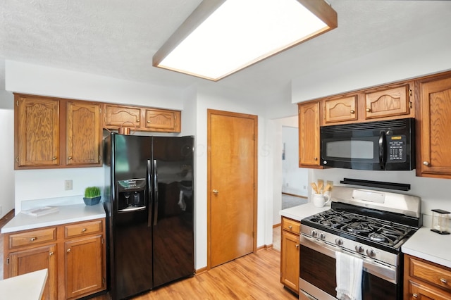 526 Springwood Lake Dr, Columbus, OH 43230 - kitchen featuring black appliances, light countertops, light wood-style floors, and brown cabinets