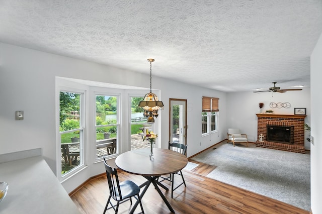 526 Springwood Lake Dr, Columbus, OH 43230 - dining area with ceiling fan, wood finished floors, a textured ceiling, and a fireplace