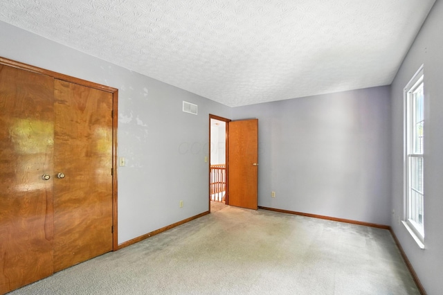 526 Springwood Lake Dr, Columbus, OH 43230 - unfurnished bedroom with multiple windows, a textured ceiling, and light colored carpet