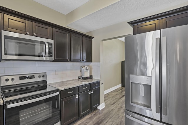 68 Asbury Ave, Newark, OH 43055 - kitchen with stainless steel appliances, dark wood finished floors, tasteful backsplash, light stone counters, and dark brown cabinetry