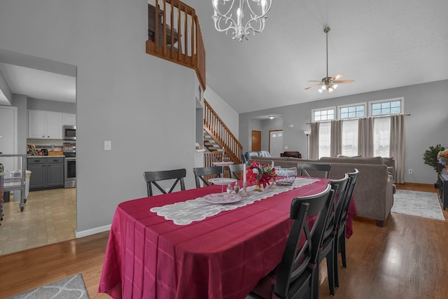 1691 Cloverdale Dr, Lancaster, OH 43130 - dining room with light wood-style flooring, ceiling fan, high vaulted ceiling, stairway, and a chandelier