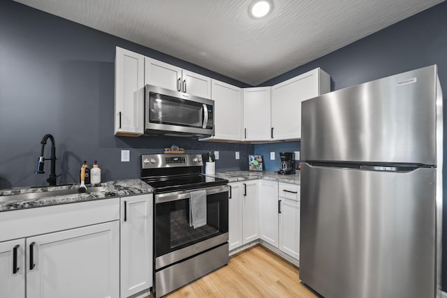 1815 Union St, Lancaster, OH 43130 - kitchen with stainless steel appliances, light wood-style floors, light stone countertops, and white cabinets