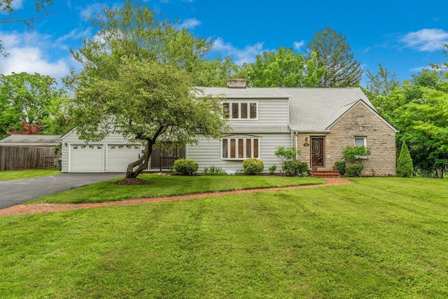1054 Highland Dr, Columbus, OH 43220 - view of front facade with driveway, a garage, stone siding, a chimney, and roof with shingles