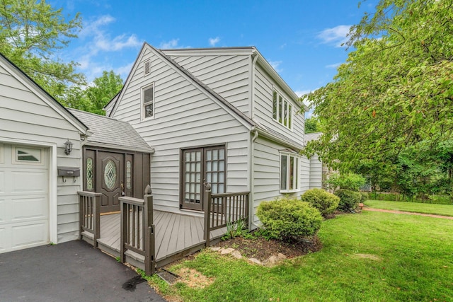 1054 Highland Dr, Columbus, OH 43220 - view of front of house with a front yard, a wooden deck, and driveway