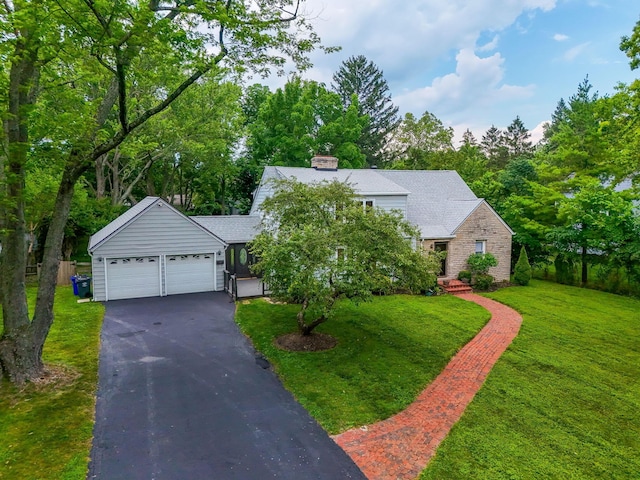 1054 Highland Dr, Columbus, OH 43220 - view of front facade featuring asphalt driveway, an attached garage, a front lawn, a chimney, and view of scattered trees