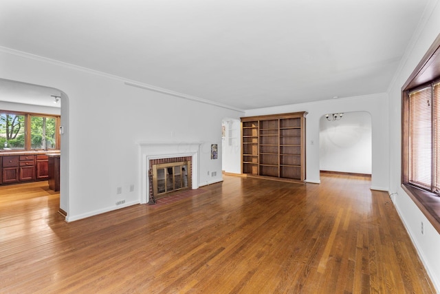 1054 Highland Dr, Columbus, OH 43220 - unfurnished living room with arched walkways, crown molding, wood finished floors, and a fireplace