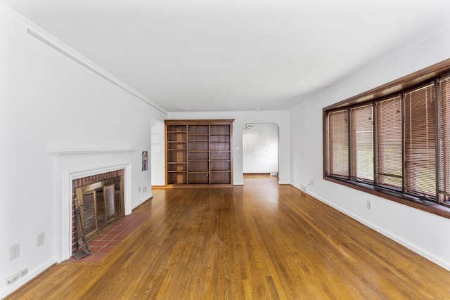 1054 Highland Dr, Columbus, OH 43220 - unfurnished living room featuring wood finished floors, arched walkways, a fireplace, and ornamental molding