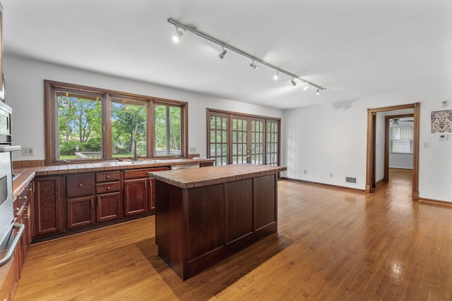 1054 Highland Dr, Columbus, OH 43220 - kitchen with tile counters, rail lighting, and healthy amount of natural light