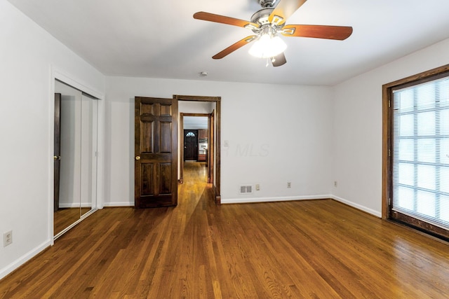 1054 Highland Dr, Columbus, OH 43220 - unfurnished bedroom featuring multiple windows, wood finished floors, and a ceiling fan