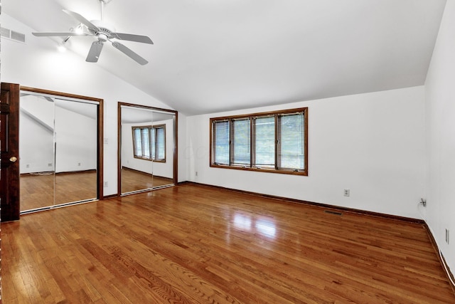 1054 Highland Dr, Columbus, OH 43220 - unfurnished bedroom featuring vaulted ceiling, multiple closets, wood finished floors, and ceiling fan