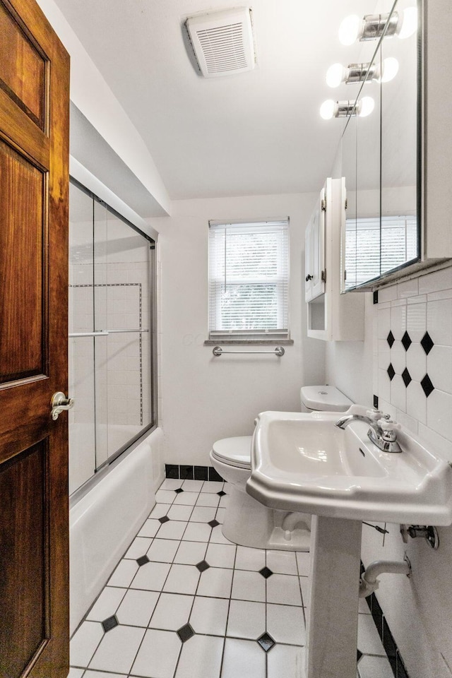 1054 Highland Dr, Columbus, OH 43220 - full bath featuring shower / bath combination with glass door, lofted ceiling, and backsplash