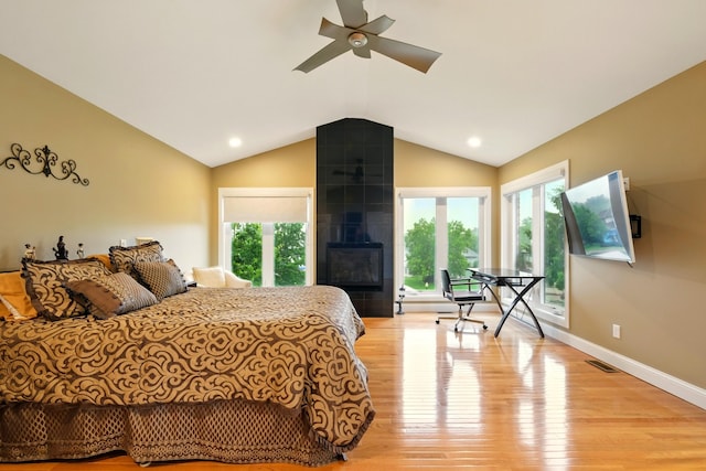 1515 Oak Run Ct, Mansfield, OH 44906 - bedroom with access to exterior, vaulted ceiling, light wood-style flooring, a tile fireplace, and multiple windows