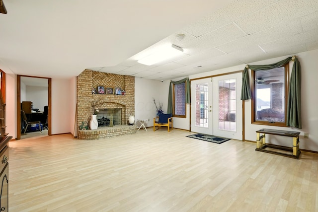 1515 Oak Run Ct, Mansfield, OH 44906 - unfurnished living room with wood finished floors, a drop ceiling, french doors, and a brick fireplace