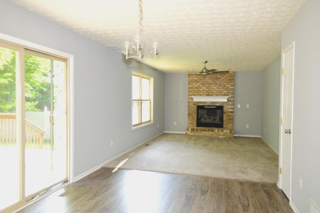 3565 Motts Place Ct, Canal Winchester, OH 43110 - unfurnished living room featuring a textured ceiling, a fireplace, wood finished floors, and a chandelier