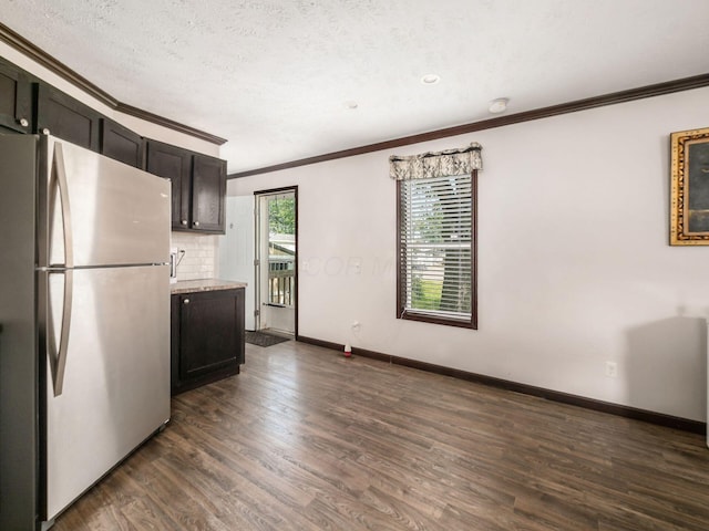 10610 E State Route 762 Unit 74B, Lockbourne, OH 43137 - kitchen featuring freestanding refrigerator, crown molding, dark wood finished floors, backsplash, and a textured ceiling