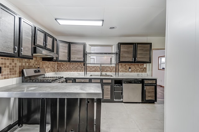 1919 Oakland Pkwy, Lima, OH 45805 - kitchen with under cabinet range hood, stainless steel appliances, light countertops, tasteful backsplash, and a peninsula