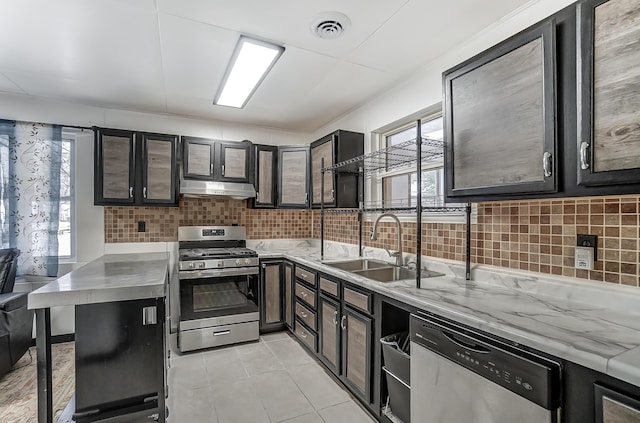 1919 Oakland Pkwy, Lima, OH 45805 - kitchen with stainless steel appliances, healthy amount of natural light, tasteful backsplash, and under cabinet range hood