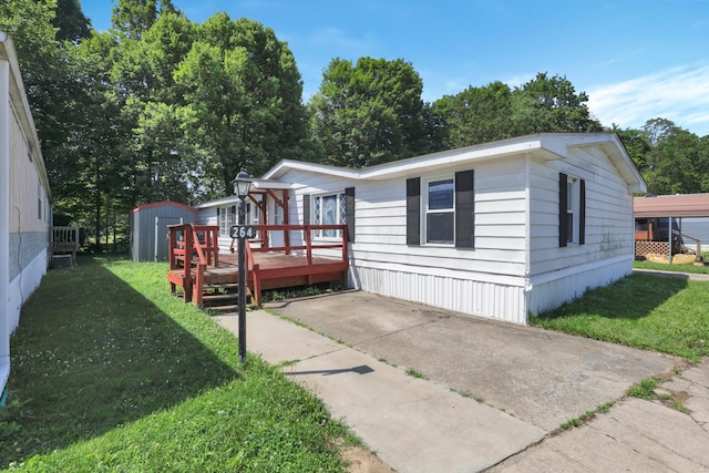264 Timberline Dr, Circleville, OH 43113 - manufactured / mobile home with a wooden deck, a storage unit, and a front yard