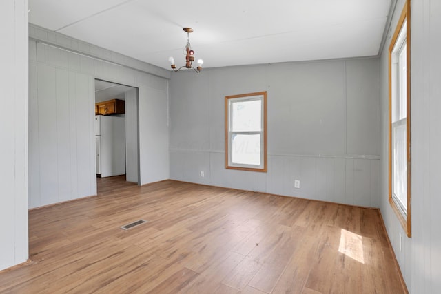 264 Timberline Dr, Circleville, OH 43113 - unfurnished room with light wood finished floors, a chandelier, and a decorative wall