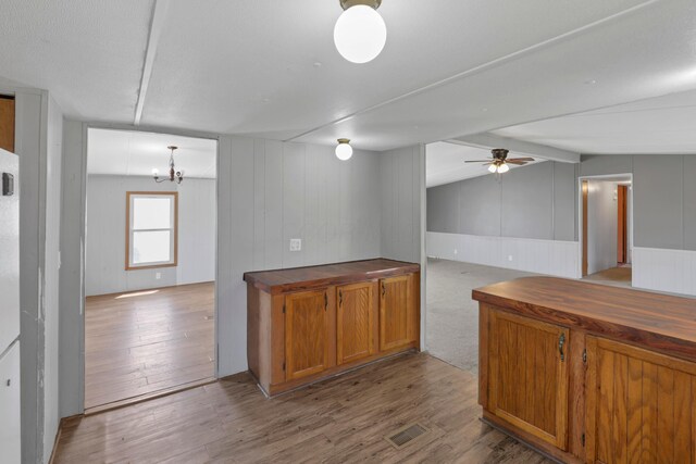 264 Timberline Dr, Circleville, OH 43113 - kitchen with brown cabinetry, wood finished floors, a ceiling fan, butcher block counters, and wood walls