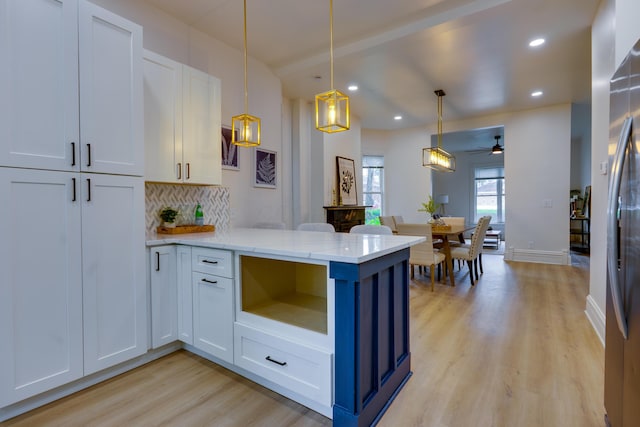 1017 Madison Ave, Columbus, OH 43205 - kitchen featuring light wood-style floors, a peninsula, ceiling fan, backsplash, and freestanding refrigerator