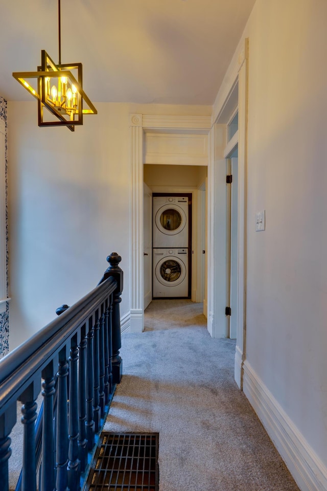 1017 Madison Ave, Columbus, OH 43205 - corridor with stacked washer / dryer, a chandelier, carpet, and an upstairs landing