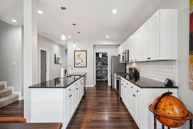 1366 Cole St, Columbus, OH 43205 - kitchen with stainless steel appliances, dark wood-style floors, recessed lighting, decorative backsplash, and an island with sink