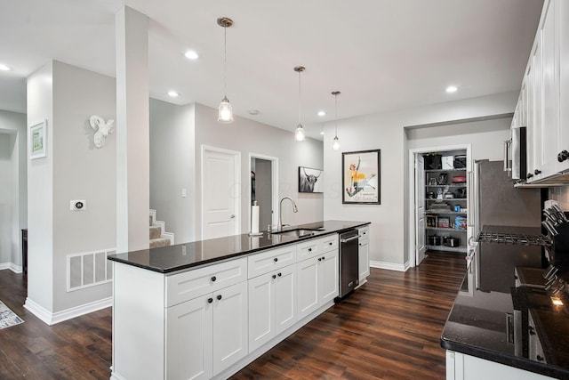 1366 Cole St, Columbus, OH 43205 - kitchen featuring stainless steel appliances, dark wood-style floors, white cabinetry, recessed lighting, and a kitchen island with sink