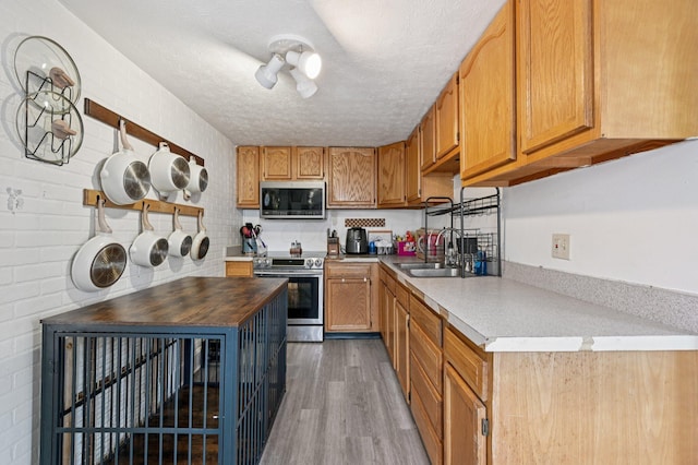 67 W Columbus St, Mount Sterling, OH 43143 - kitchen with stainless steel appliances, a textured ceiling, wood finished floors, wood counters, and brown cabinetry