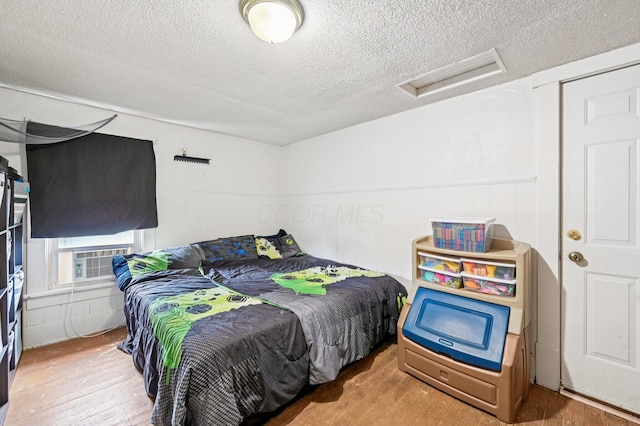 67 W Columbus St, Mount Sterling, OH 43143 - bedroom featuring attic access, a textured ceiling, hardwood / wood-style flooring, and cooling unit