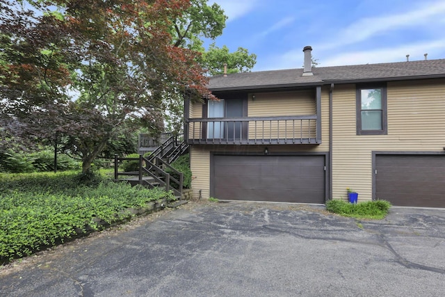 3117 Rivermill Dr Unit 25, Columbus, OH 43220 - view of front of property featuring an attached garage, driveway, stairway, and roof with shingles